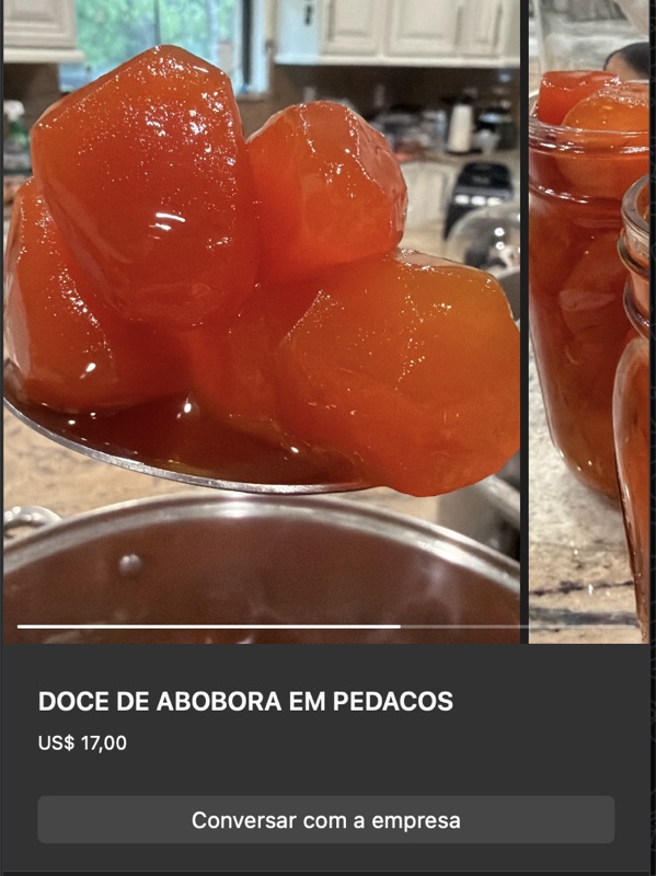 Pedaços grandes de abóbora cristalizada cozida em calda, cor laranja escura translúcida, brilhando em colher. Ao fundo, mais doce em recipiente.