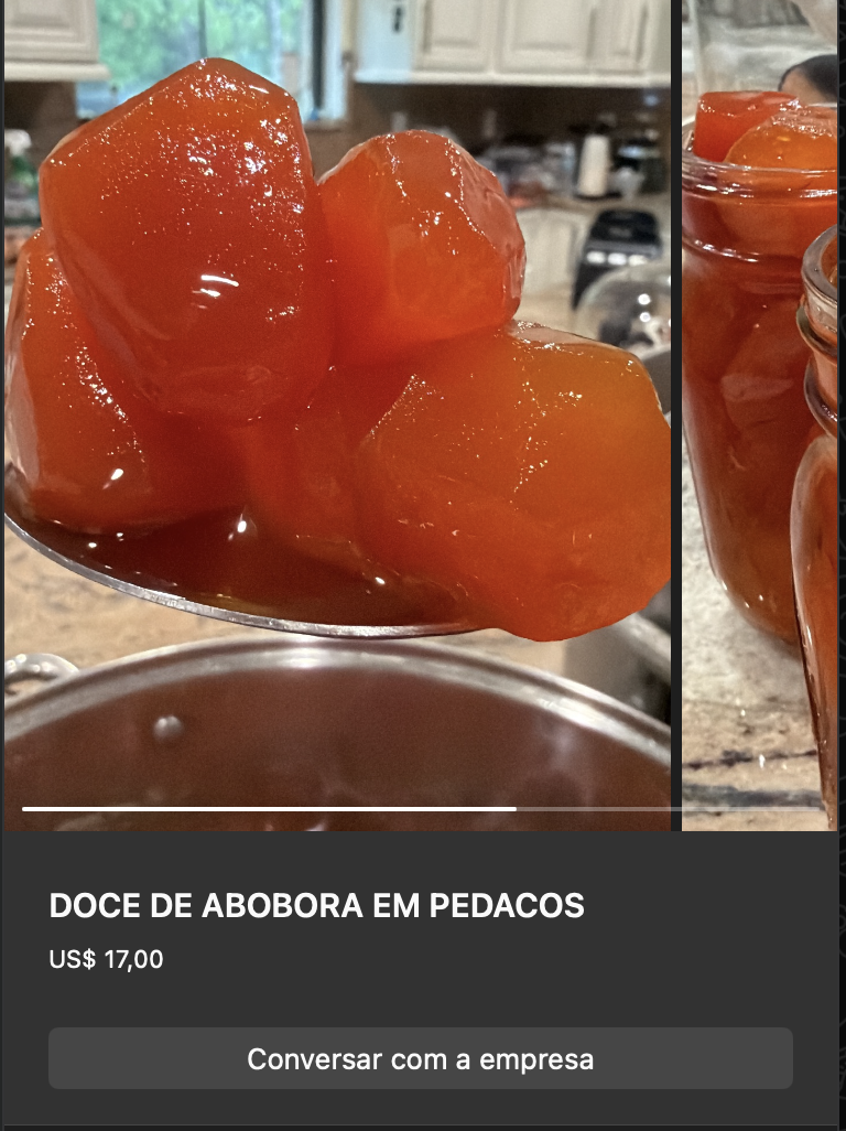 Pedaços grandes de abóbora cristalizada cozida em calda, cor laranja escura translúcida, brilhando em colher. Ao fundo, mais doce em recipiente.