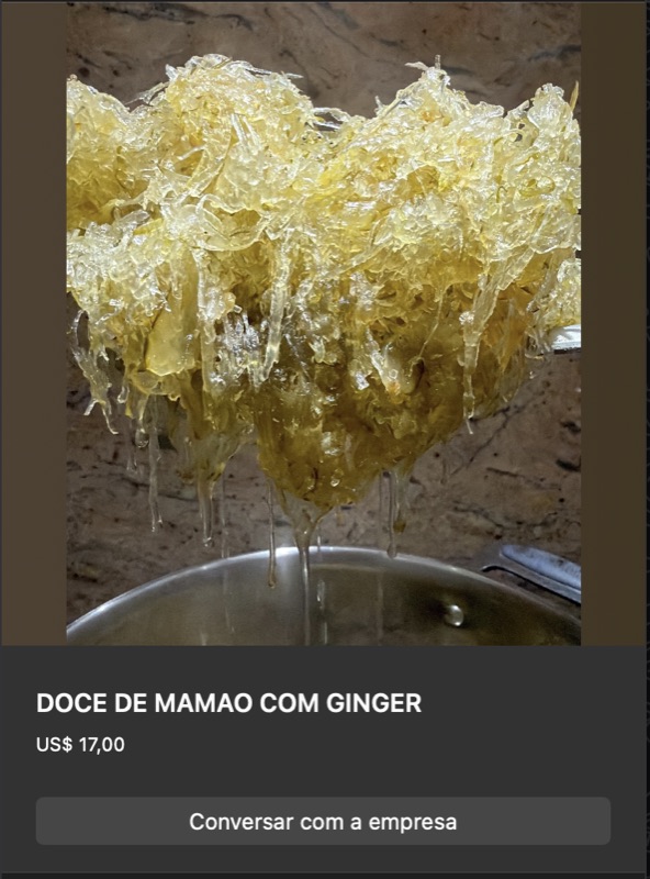 Doce de mamão verde ralado em fios longos amarelo-dourados, brilhante de calda, transbordando de pote. Textura fibrosa típica de doce de mamão verde com gengibre.