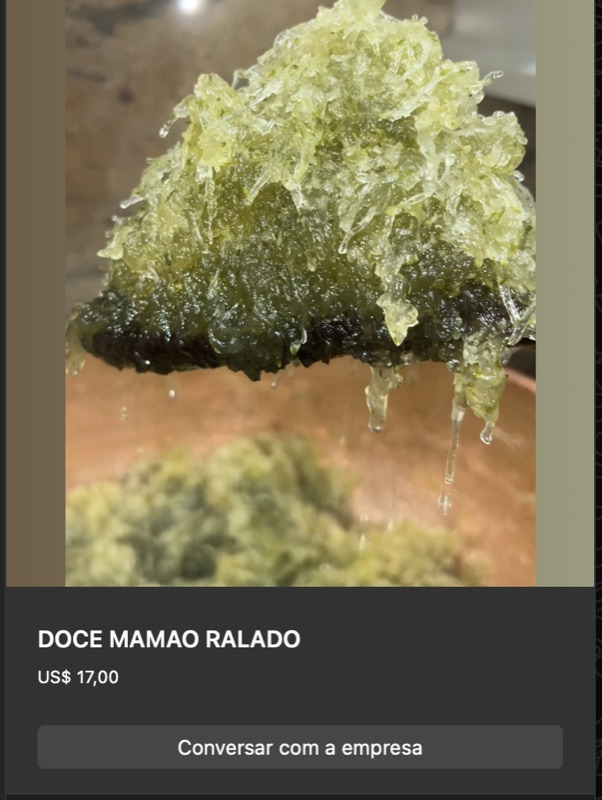 Doce de mamão verde ralado em fios verde-amarelados, brilho intenso da calda escorrendo. Aparência caseira fresca.