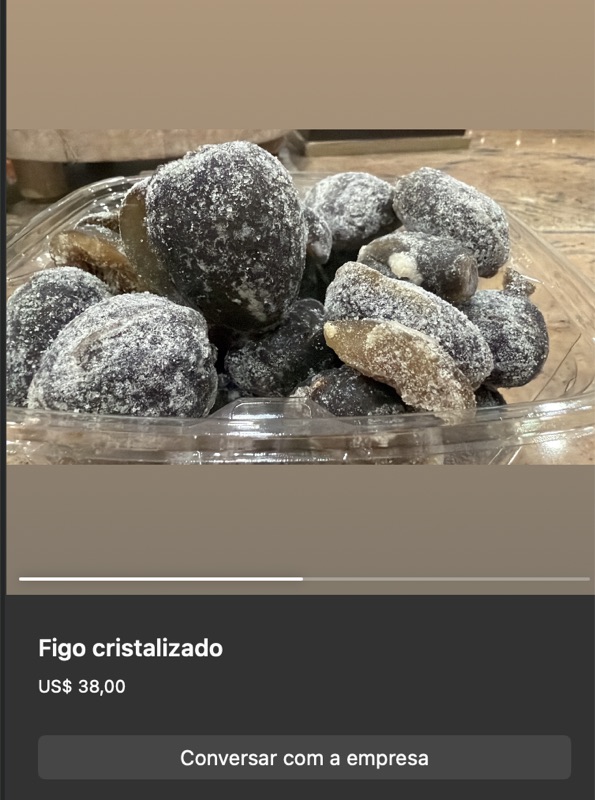 Travessa de vidro com figos inteiros cristalizados, cobertos por crosta de açúcar branca, cor escura sob a crosta. Apresentação artesanal típica.