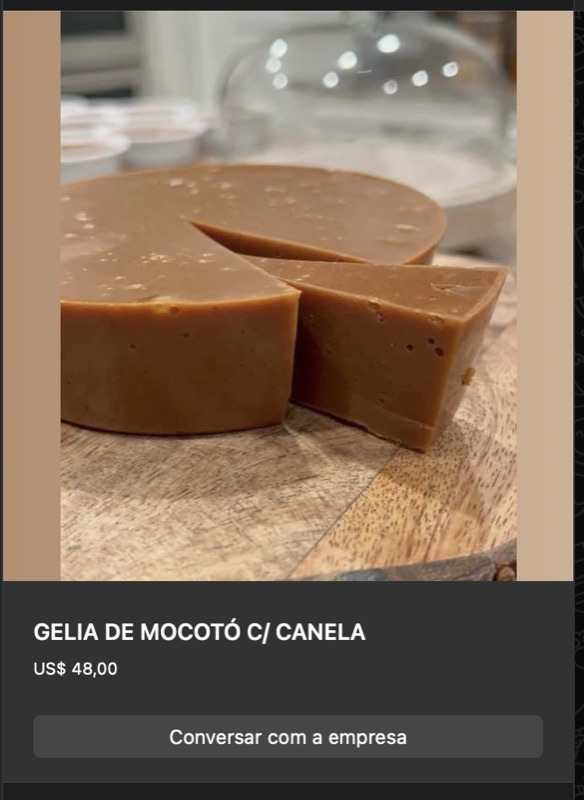 Disco firme de geleia de mocotó com canela em tom marrom-caramelo uniforme, cortado em pedaços sobre tábua de madeira. Aspecto liso e denso.
