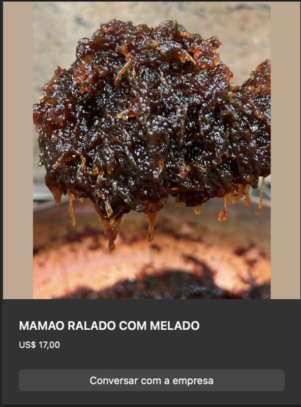 Doce de mamão ralado com melado em tom marrom-escuro intenso, textura fibrosa e brilhante. Calda viscosa visível pingando.