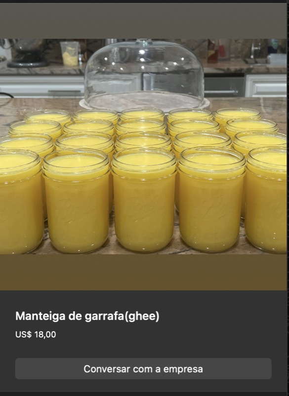 Vários potes pequenos de vidro com manteiga de garrafa (ghee) clarificada, cor amarelo-dourada brilhante translúcida. Dispostos em fileiras sobre balcão.