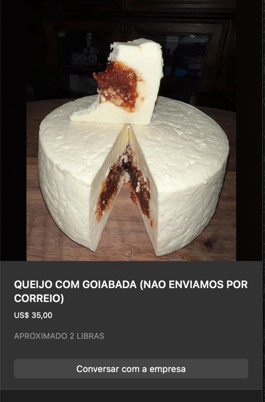 Queijo branco fresco redondo grande, cortado ao meio mostrando núcleo recheado com goiabada vermelha visível. Aproximadamente 2 libras.