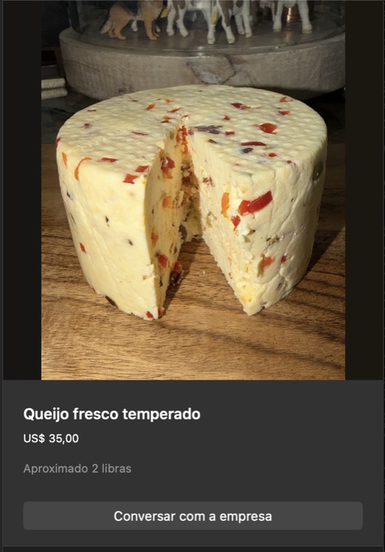Queijo fresco redondo branco com pedaços visíveis de pimentões vermelhos e ervas verdes incorporados na massa. Corte mostrando interior. Aproximadamente 2 libras.