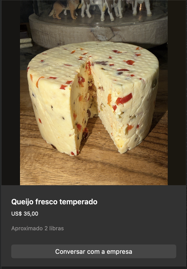 Queijo fresco redondo branco com pedaços visíveis de pimentões vermelhos e ervas verdes incorporados na massa. Corte mostrando interior. Aproximadamente 2 libras.