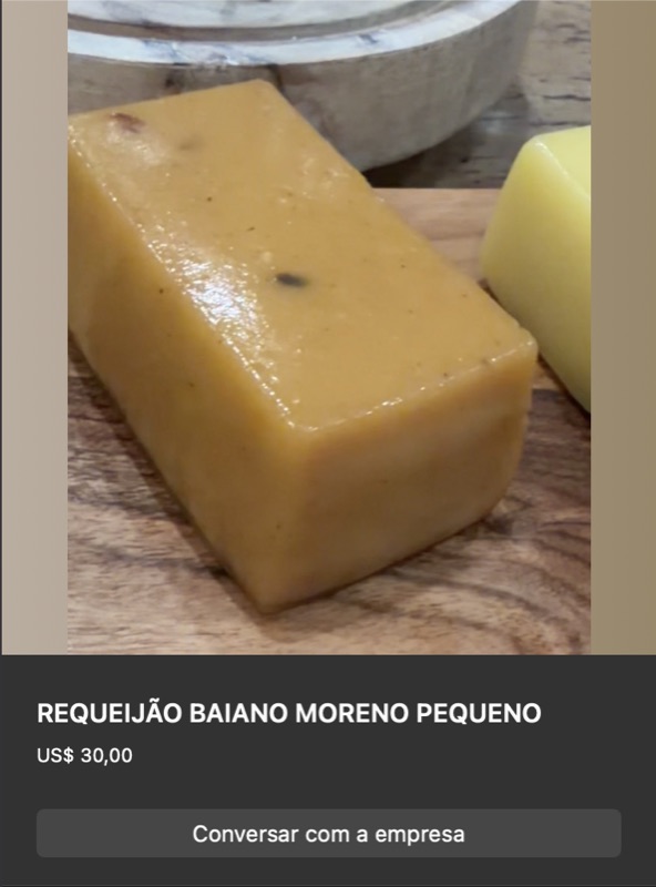 Bloco pequeno retangular de requeijão moreno em cor caramelo-dourada uniforme, ao lado de queijo branco e limão. Apresentação simples sobre balcão claro.